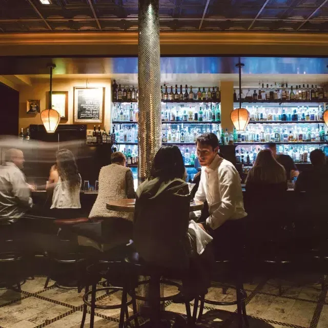 Una coppia beve un drink in un affollato bar di San Francisco.